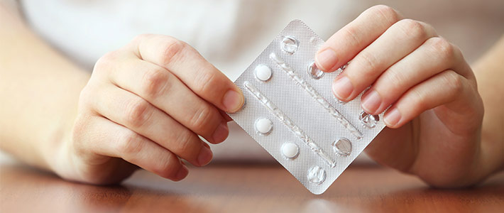 Eine Frau nimmt Medikamente in Form von Tabletten.